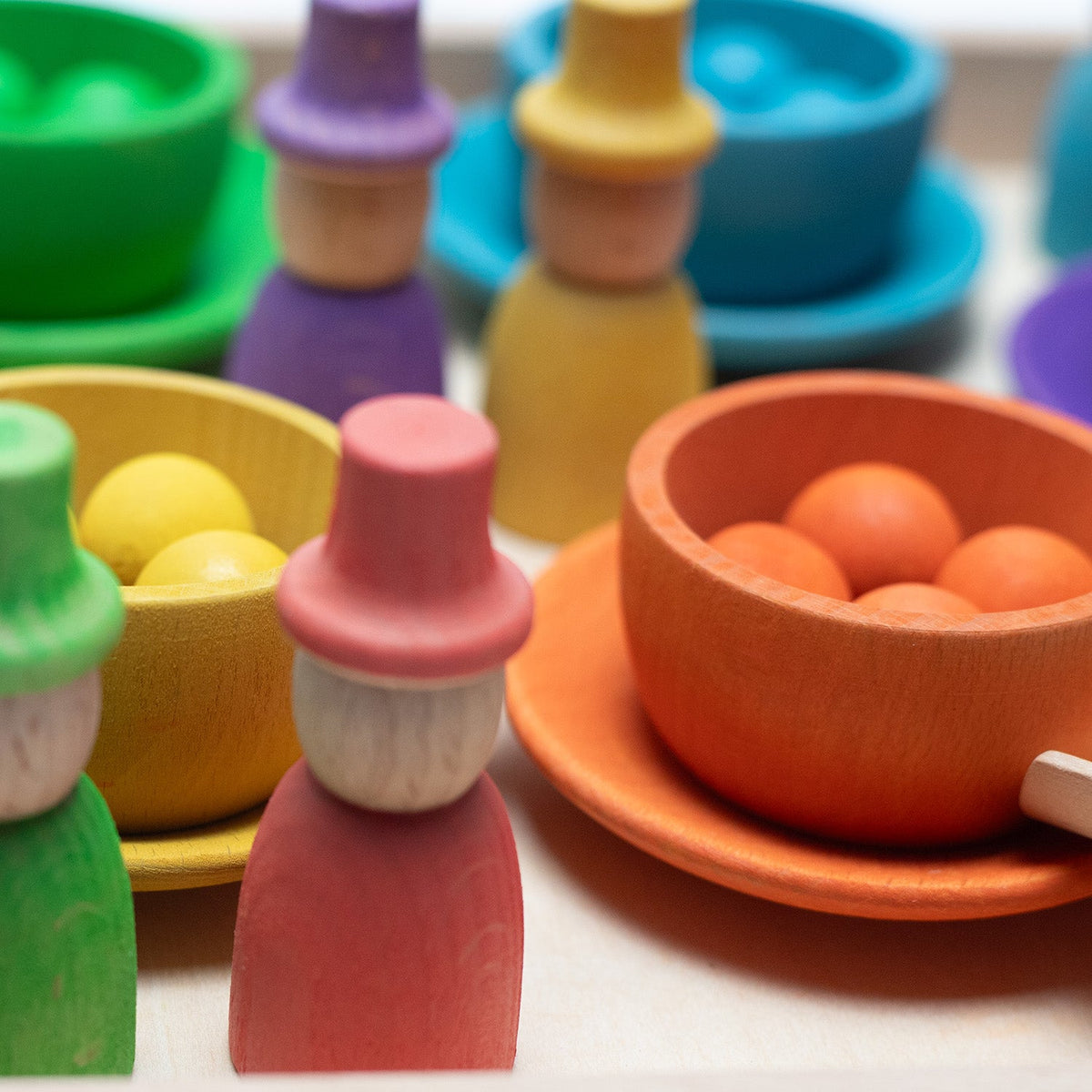 Houten speelgoed – Gekleurde poppetjes, schaaltjes en balletjes op dienblad